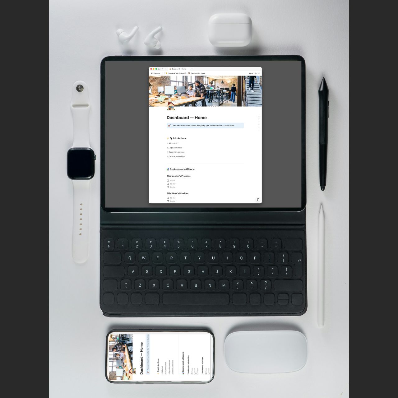 Tablet with keyboard, smartphone, mouse, and office items on a white surface